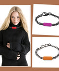 Woman wearing black sweater with red dog tag necklace, purple and orange tag bracelets displayed