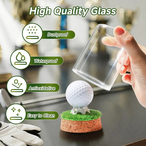 Hand placing cover on Hole In One Golf Ball Display Case With Crystal Clear Glass Stand, Premium Cork Base, Lifelike Turf, And Plastic Tee