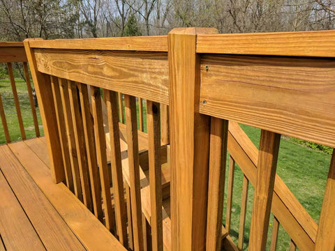 Wooden deck railing with semi transparent outdoor wood stain and sealer in one for decks fences and siding water based UV protection.