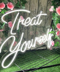 Treat Yourself Neon LED Light For Walls amid pink roses and green leaves, perfect for bedroom decor or any celebration, 21.65 x 15.7 inches
