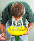 Person using Yellow Wall Mounted Emergency Eyewash Station With Dual Spray Heads And Hands Free Activation 15 Minute Flush Traditional Series Safety Eyewash For Industrial Lab And Workplace Environments.