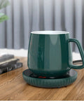 Tempered Glass Top Cup Warmer Pad With Digital Display And Auto Timer To Keep Your Morning Brew Piping Hot And Dodge The Cold Coffee Blues On Busy Weekdays with a green ceramic mug on a wooden table.