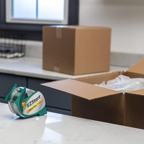 EZ Start Clear Packing Tape Refills For Shipping Moving And Storage 6 Rolls 1.88 Inch By 55 Yards placed on a counter near boxes