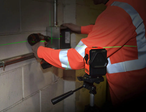 Worker using Self Leveling Cross And Line Laser Kit With GreenBrite Technology Green Beam for precise indoor alignment