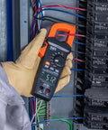 Electrician using Auto Ranging Digital Clamp Meter With True RMS For AC And DC Current And Voltage Resistance Continuity Frequency Capacitance