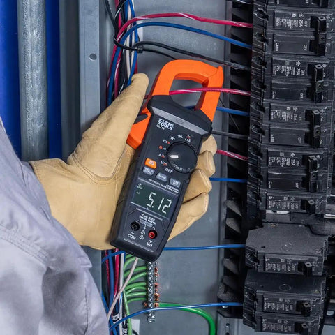 Electrician using Auto Ranging Digital Clamp Meter With True RMS For AC And DC Current And Voltage Resistance Continuity Frequency Capacitance