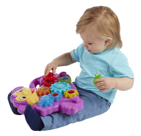 Child playing with Totally Awesome Dope Monkey Gears Stacking And Spinning Toy, colorful plastic cogs in hand.