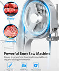 Heavy Duty 1500W Electric Bone Saw Works Like A Champ Crushing Frozen Beef Chicken Fish And Pork Blocks Up To Five Point Nine Inches Thick Includes Six Razor Ready Blades For Low Stress Prep On A Roomy Twenty By Fifteen Inch Commercial Table, close-up of sharp saw blade and motor.