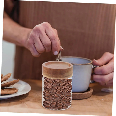 Close-up of 3 Piece Airtight Glass Canister Set designed for loose tea and spices with coffee beans visible inside.