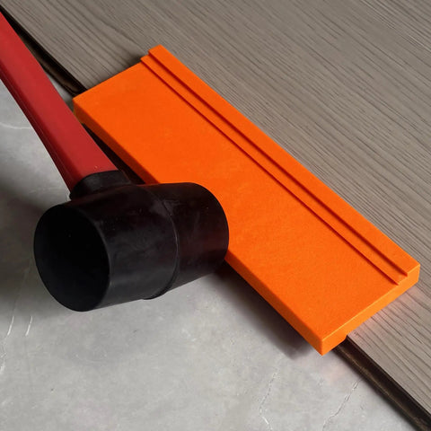 Pro Grade Three Edge Tapping Block for Vinyl Flooring and Laminate Installations next to mallet and flooring plank