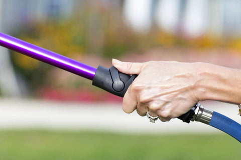 Close-up of a hand gripping the one-touch thumb control valve on the RainSelect Rain Wand 30 Inch Aluminum Garden Watering Wand Green
