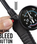 Close-up of High Pressure Bike Shock Pump with 300 PSI Gauge, finger pressing bleed button, Schrader and Presta valve compatible