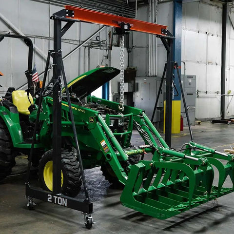 2 Ton Push Trolley For Beams Three And A Half Inch To Eight Inch Adjustable Lifting Trolley supporting a green tractor in shop