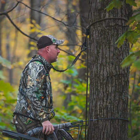 Hunter using Rope Style Tree Strap For Hunting Safety, 9 Foot Length, Durable Rope Attachment for secure tree stand setup.