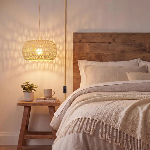 Qingmiao Boho Plug in Pendant Light with handwoven shade hanging above a bed, showcasing a cozy bedroom setting.