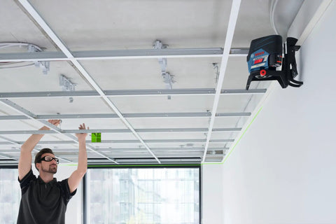 Pro Level 12V Green Beam Cross Line Laser With 100 Foot Reach And Smart Visimax Tech projecting green lines for accurate ceiling installation.