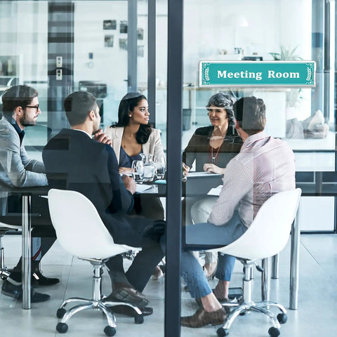 Office meeting room with people around a table, showing Clear Acrylic Name Plates With Adhesive Tapes Five Pack For Doors And Walls 2x8 Horizontal Name Plate Holder Office And Classroom Sign Frame Pro Grade For Easy Paper Insert Replacement.