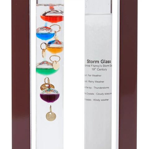 Close-up of Cool Indoor Weather Station With Glass Galileo Thermometer And Five Multicolor Balls From 64F To 80F in cherry wood frame