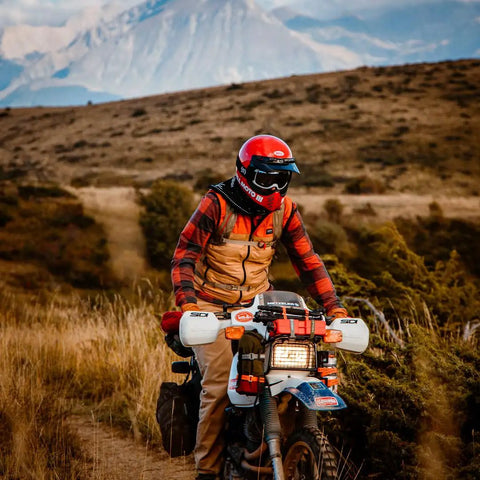 Person on a motorcycle in rugged landscape, wearing red helmet and gear, suitable for Heavy Duty UV Resistant Beefy Polyurethane Straps Set 3 Pack