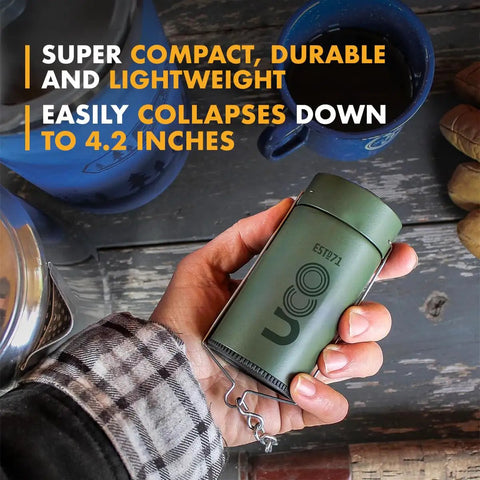 Hand holding Candle Lantern Value Pack With 3 Candles And Storage Bag Original Size Powder Coated Aluminum Forest Green Collapsible Camp Light.