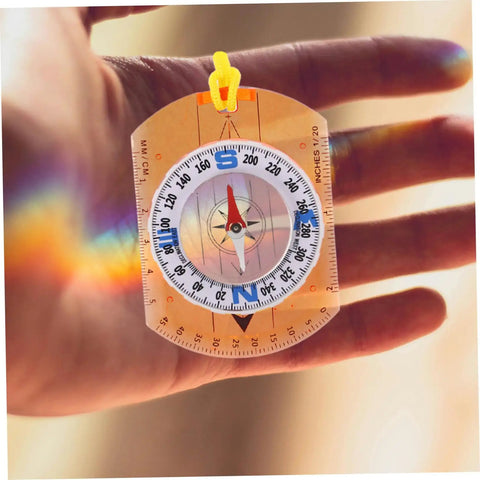 Adventure Ready Outdoor Precision Compass With Safety Lanyard in hand, showing ruler and luminous north pointer.