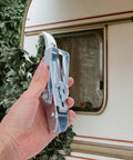 Hand holding Heavy Duty Trailer Gate Latch Kit with Adjustable Over Center Toggle Latches near a caravan window