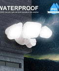 Lit 42W LED Outdoor Flood Light With Motion Sensor mounted on wall, illuminating in rain, 3 adjustable heads, IP66 waterproof