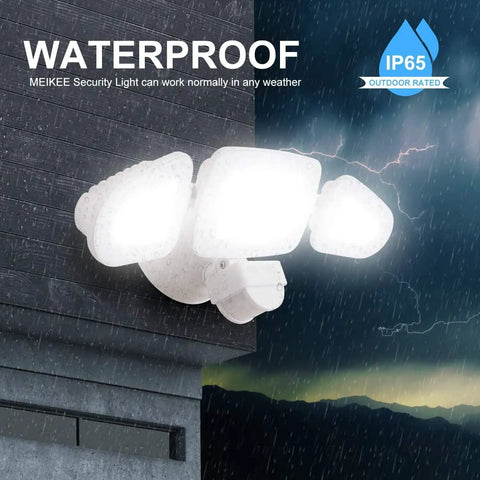 Lit 42W LED Outdoor Flood Light With Motion Sensor mounted on wall, illuminating in rain, 3 adjustable heads, IP66 waterproof