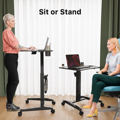 Height Adjustable Rolling Laptop Desk With Cup Holder And Wheels 27 Inch Portable Sit Stand Workstation On Pneumatic Lift Ergonomic Curved Desktop For Comfortable Working Black in use by standing and seated individuals