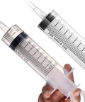 Heavy Duty 100 Ml Plastic Syringes Two Pack With Slick Catheter Tips For Garden Watering Measuring And Lab Refills held in hand.