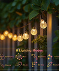 Solar String Lights For Outdoor 20Ft 30 LED Crystal Globe Fairy Lights Warm White With 8 Lighting Modes hanging on a garden fence