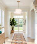 16" White and Gold Drum Pendant Light with Metal Lantern Fabric Shade hanging in a bright hallway with large windows.