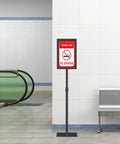 Heavy Duty 11x17 Standing Sign Holder With Adjustable Pedestal in indoor hallway, displaying 'No Smoking' sign