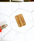 Brass Hinges For Wooden Boxes And Furniture Self Closing Cabinet Hardware Kit with pliers on white hex tile