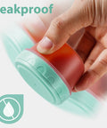 Hand holding Leakproof Salad Dressing Containers To Go With Lids 6 Pack 2.7 Oz Small Sauce Jars For Lunch, showing leakproof feature.