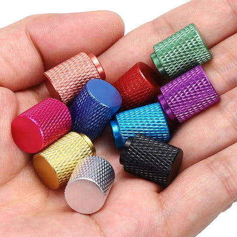 Colorful knurled thumb nuts in hand, multi-color anodized, assorted sizes for electronics, machinery, DIY projects.