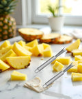 Two Pack Stainless Steel Pineapple Eye Peeler And Remover Tool, V Shape Eye Cutter with sliced pineapples on a kitchen counter