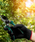 Hand holding pruning shears while wearing Tough As Nails Nitrile Coated Work Gloves Bulk Pack Of 72 Pairs For Mechanics And Yard Jobs.