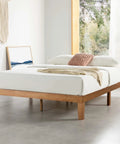 Queen Platform Bed Frame Low Profile Solid Pine Wood with plush pillows and throw blanket in a bright bedroom setting.