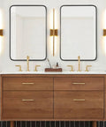 Two Pack Matte Black Wall Sconces With Clear Glass Shades flanking bathroom mirrors over wooden vanity