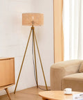 60 Inch Floor Lamp With Faux Wood Tripod Base And Rattan Shade On Off Rotary Switch For Easy Control in a cozy living room