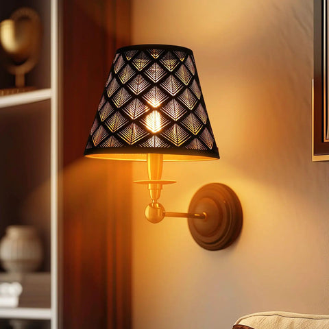 Wall-mounted lamp with intricate patterned shade casting warm light in a living room.