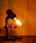 Old School Edison Style LED Filament Tubular Bulb in vintage fixture on wooden background, warm glow, E26 Dimmable, 2700K, 40W Equivalent