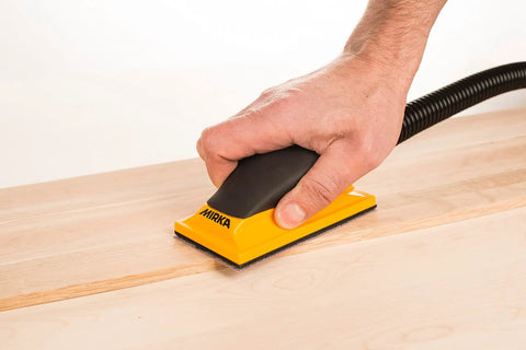 Hand using Ergonomic Pro Grade 2.75 by 5 Inch Dust Free Hand Sanding Block With 13 Hole Hook And Loop System on wood surface