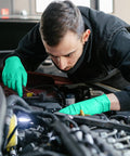 Person using Kick Ass Chemical Resistant Gloves 10 Pack Heavy Duty Nitrile Work Protective Gear while repairing a car engine.