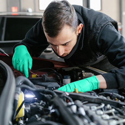 Person using Kick Ass Chemical Resistant Gloves 10 Pack Heavy Duty Nitrile Work Protective Gear while repairing a car engine.