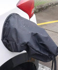 Magnetic EV Port Protector Hella Waterproof Plug Cover on EV, black canvas with rain droplets, universal fit for vehicle charging ports.