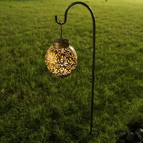 Two Pack Adjustable Shepherd Hooks With Heights Of Thirty One Twenty Four And Sixteen Inches Heavy Duty One Half Inch Thick Black Outdoor Hangers For Lanterns Solar Lights Bird Feeders Planters Wedding Aisles And Yard And Patio Garden Decor with a lit lantern hanging in yard.