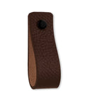 Close-up of a single brown leather drawer pull from the 12-piece set, featuring black screw, sized 6.5 x 1 inches for furniture use.