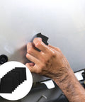 Person using Top Notch Wet And Dry Sandpaper Assortment Pack With 60 To 320 Grit Sheets on car surface for polishing.